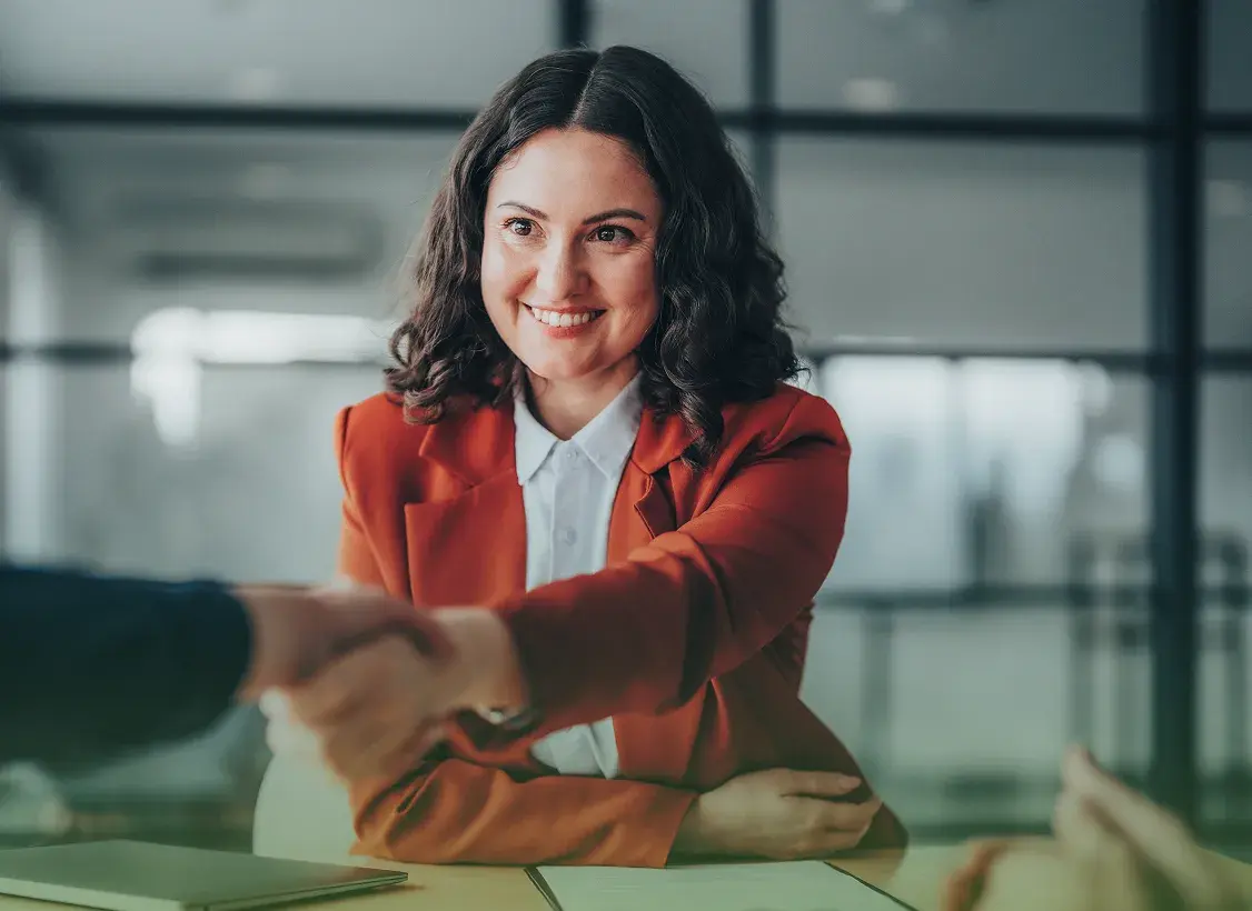 A Custom Design Benefits team member welcoming a job candidate with a handshake
